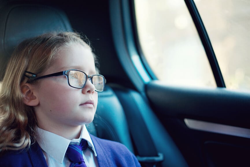 a girl with glasses in the backseat