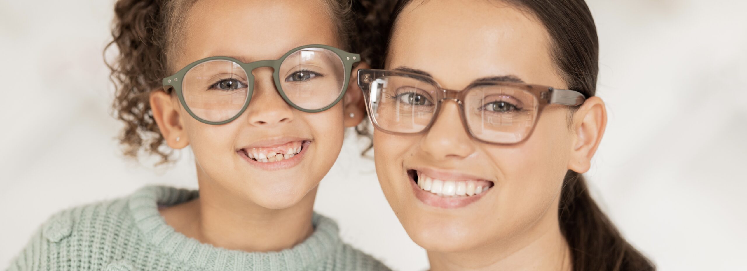 Mother, girl and glasses in optometry shop, frame and happy after shopping in retail store with smile for vision result. Portrait of latino mom, child and happiness with optical lense at optometrist.