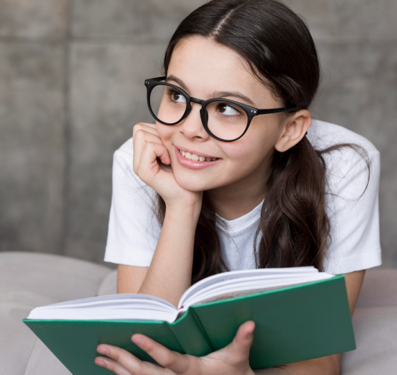 kid-reading-a-book-while-smiling-sideways