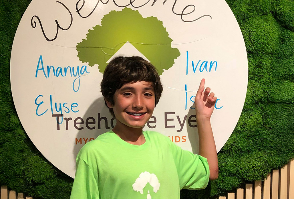 boy pointing at treehouse myopia logo